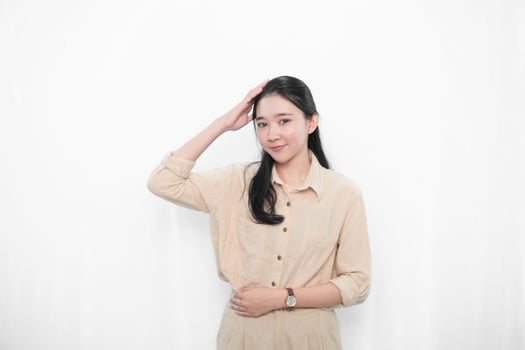 Expression of Indonesian Asian model woman in white dress smiling and holding her head photo