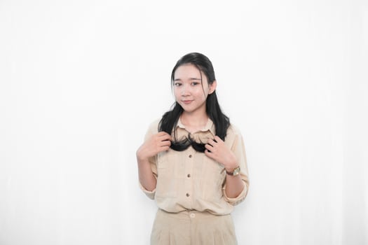 Expression of Indonesian Asian model woman in white dress smiling and holding hair photo