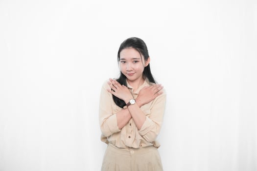 Expression of Indonesian Asian model woman in white dress smiling and crossing her arms on her chest photo