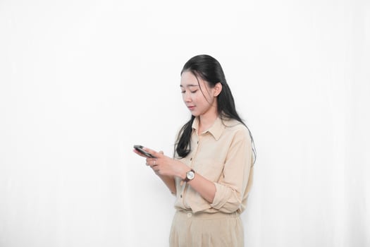 The expression of an Indonesian Asian model woman in white is showing sending a message with a smartphone. photo