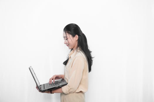 Expression of an Indonesian Asian model woman in white using a laptop photo