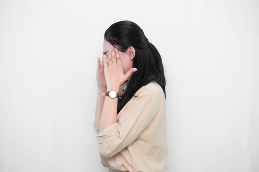 Expression of Indonesian Asian model woman in white dress with headache or confusion photo