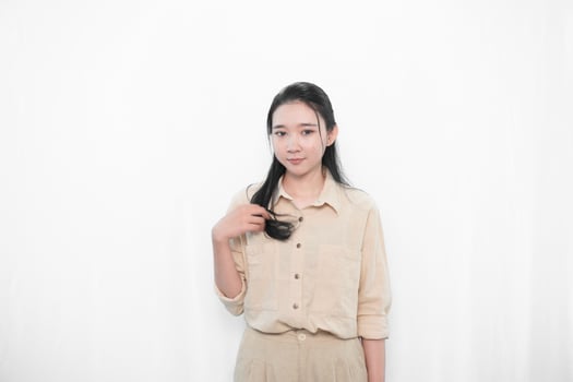 Expression of Indonesian Asian model woman in white dress smiling and holding hair photo