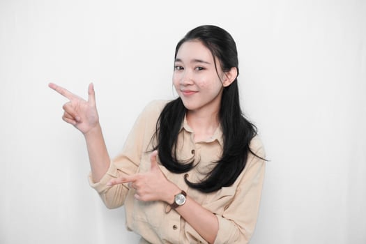 Expression of Indonesian Asian model woman in white dress smiling and making gun sign photo