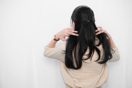 Expression of Indonesian Asian model woman in white holding hair photo