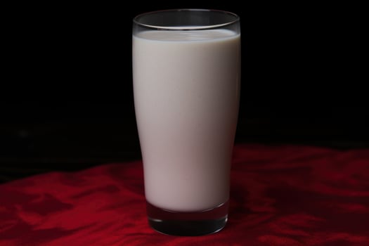 glass of creamy milk on red cloth photo