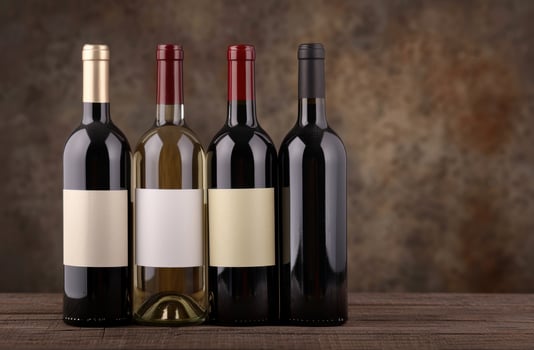 Assortment of red and white wine bottles on wooden table photo