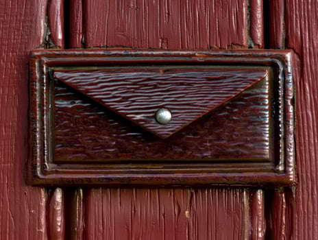 Vintage wooden drawer handle on red painted surface photo