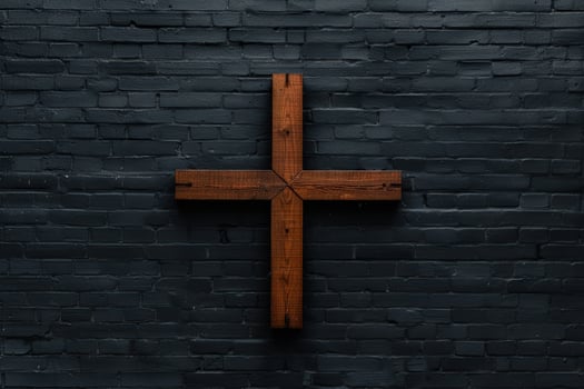 Wooden cross against dark brick wall photo