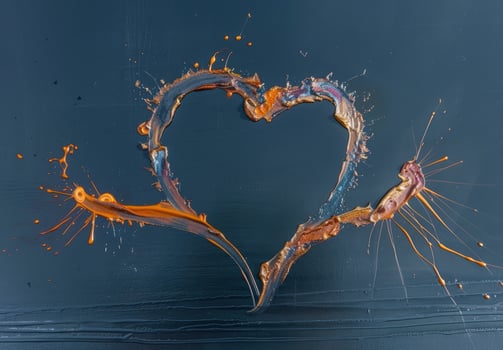 Splash of orange paint forming a heart shape photo
