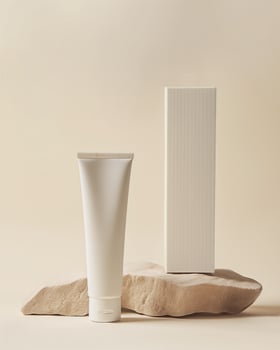 A tube of cream and a box of cream on a beige background photo