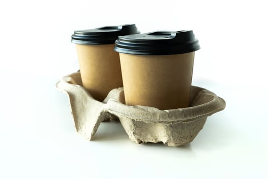 Takeaway paper coffee cups with plastic lids and cardboard holder in cardboard holder on white background, eco friendly, biodegradable photo