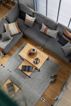 Stylish composition of living room interior with corner grey sofa, green velvet armchair, coffee table, wooden floor, design furniture and minimalist personal accessories. Modern home decor. photo