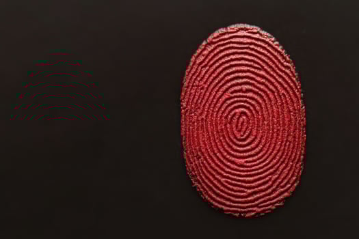 An artistic representation of a red fingerprint on a black background. photo