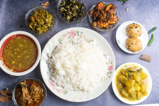 Plain Rice, Ilish fish curry, Plain daal, Snake gourd fry, Chichinga bhaji, Okra Fry, bhindi fried, Chingri mach, fried shrimps, Alu bhorta, green papaya stir fry and pepe curry photo