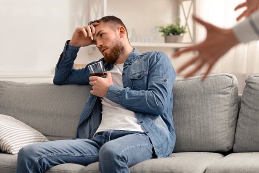 Alcoholism problem. Angry woman quarreling with her drinking husband at home photo