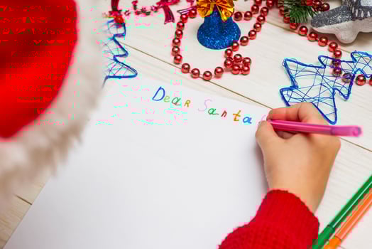 Little boy in Santa hat writes letter to Santa Claus photo