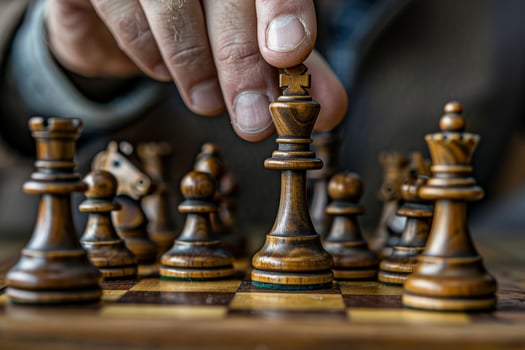 A man is playing chess and is about to move his king photo
