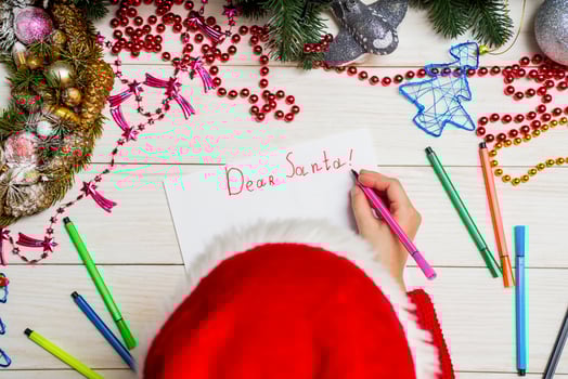 Little boy in Santa hat writes letter to Santa Claus photo