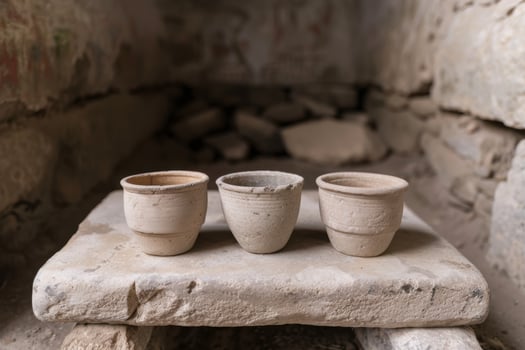 ancient clay cups on stone shelf photo