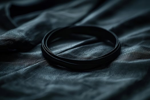 Closeup of a black camera lens filter on dark fabric photo