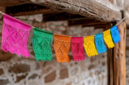 Colorful Mexican paper flags hanging in front of a rustic wooden wall photo