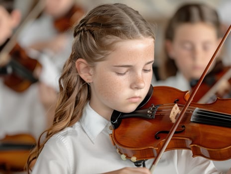 young musician playing violin in orchestra photo