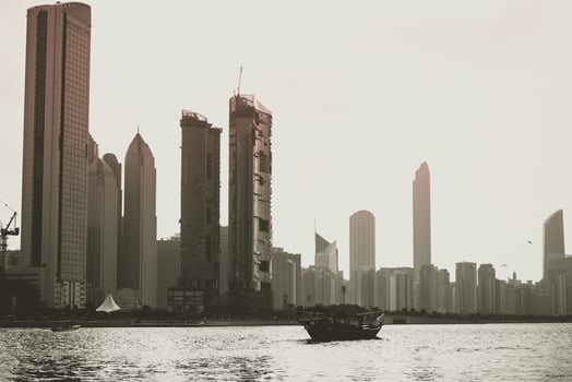 Abu Dhabi buildings skyline with old fishing boat photo