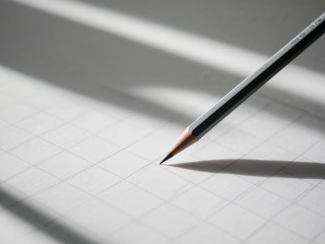 A pencil is on a piece of paper with a grid. photo