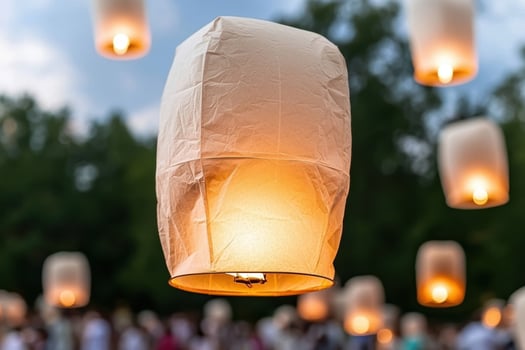 Illuminated paper lanterns floating in the night sky photo