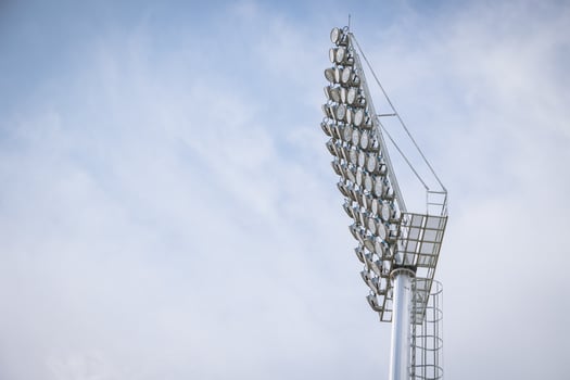 Stadium large high power lighting, Floodlights over a sports field outdoors against blue sky. photo