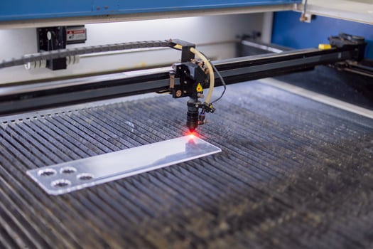 Closeup industrial CO2 laser cutting machine working with high powered red laser beam on acrylic or glass plate photo