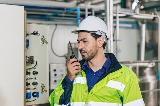 Engineer working, Factory male Latin worker in a oil and gas power plant with control operate order with walkie-talkie communication at work photo