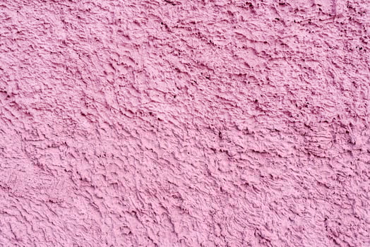 Pink texture of uneven plaster on the wall of the house. photo