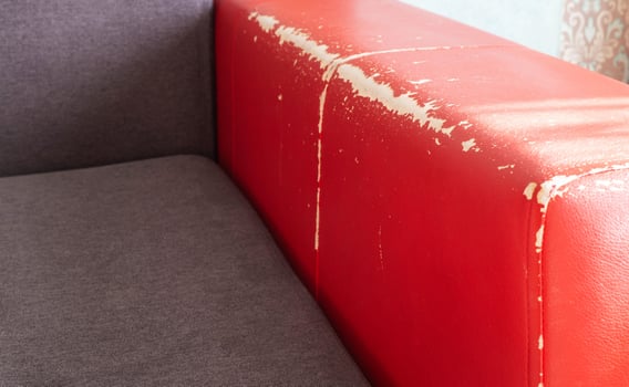 Torn and battered leather back of the sofa. Poor quality leather, leather cleansing and restoration photo