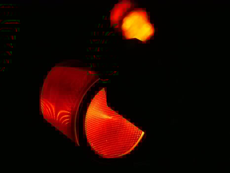 Red traffic light close up in the dark on a black background photo