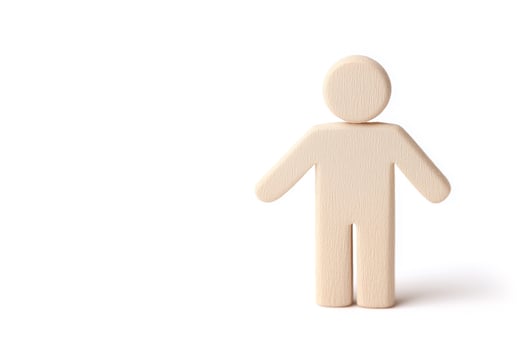Wooden figure standing on white background with copy space photo