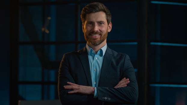 Confident strong Caucasian businessman adult middle-aged 40s man posing in night office with crossed hands. Female entrepreneur leader company agent lawyer smiling toothy smile stand with folded arms photo