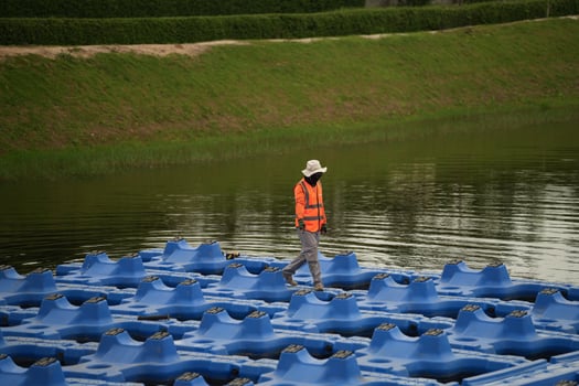 A man walking on a floating platform over a body of water photo