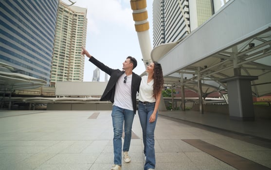 A man and woman are standing in front of a tall building photo
