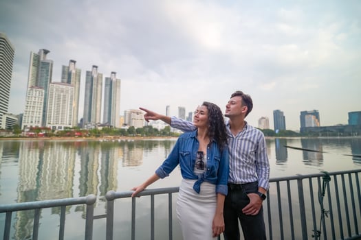 A couple standing on a bridge overlooking the city photo