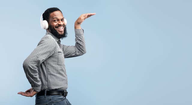 Music Is My Life. Excited african man wearing headset and dancing disco isolated over turquoise studio wall photo