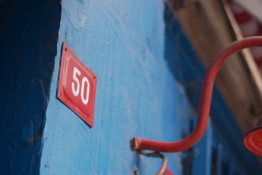 A Vibrantly Colored Blue Wall Featuring the Number 50 Accented with Red Detail and Artistry photo
