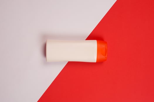 Plastic shampoo bottle with flip-top lid isolated on red and white background. MockUp template for your design. Empty and clean packaging for cosmetic product. File contains clipping path. photo