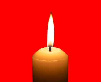A single burning candle flame or light glowing on a big white candle isolated on red background with clipping path photo