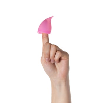 Pink menstrual cup put on the finger of a woman's hand on a white background, isolate. Gynecology photo