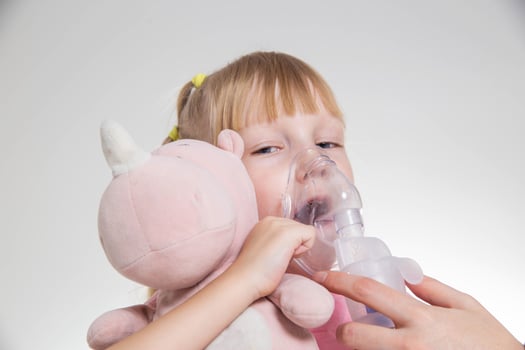 A 5-year-old girl breathes into an inhaler to dilute sputum in case of lung diseases. Treatment of cough in children. Nebulizer therapy photo