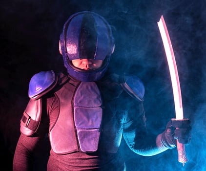 Cyberpunk future concept. Bionic cyborg police officer with short samurai sword stands in dark with smoke, fume. Halfman robot looks at camera. Futuristic science fiction scene. photo