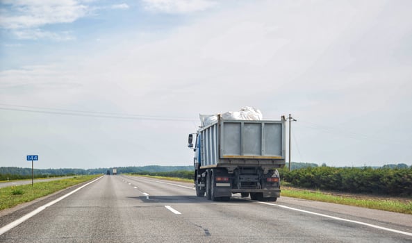 Transporting waste in a dump truck on the highway for recycling. Transportation of recyclable materials to a processing plant. Copy space for text, industry photo