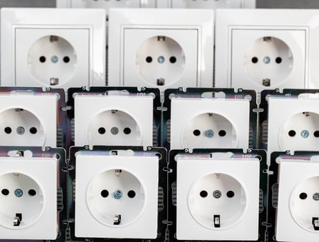Many modern electrical sockets on a gray background, close-up. Rise in the price of electricity price per kilowatt, saving electricity, close-up photo